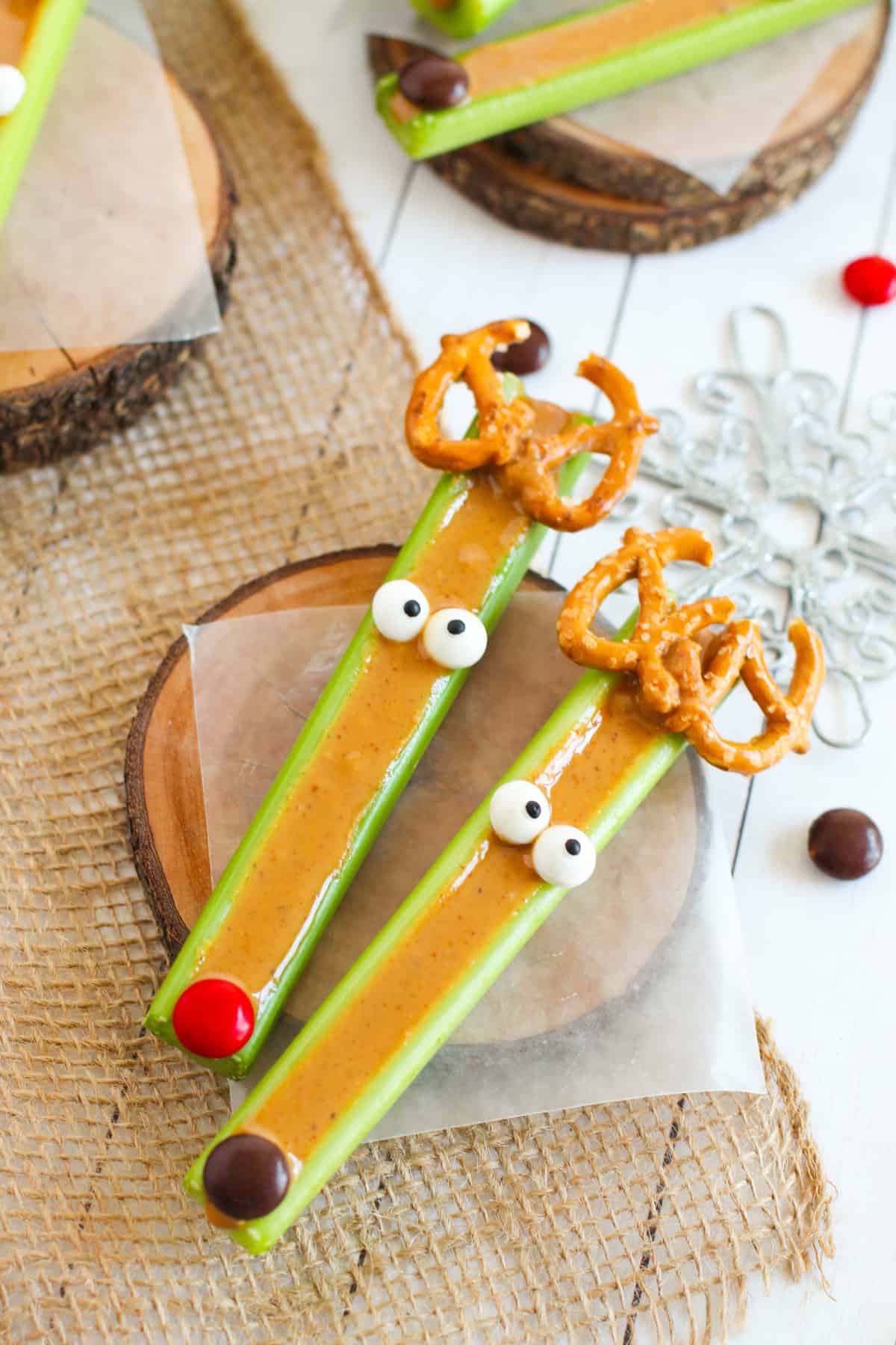 Two reindeer celery sticks, one with red nose like Rudolph and one with a brown nose.