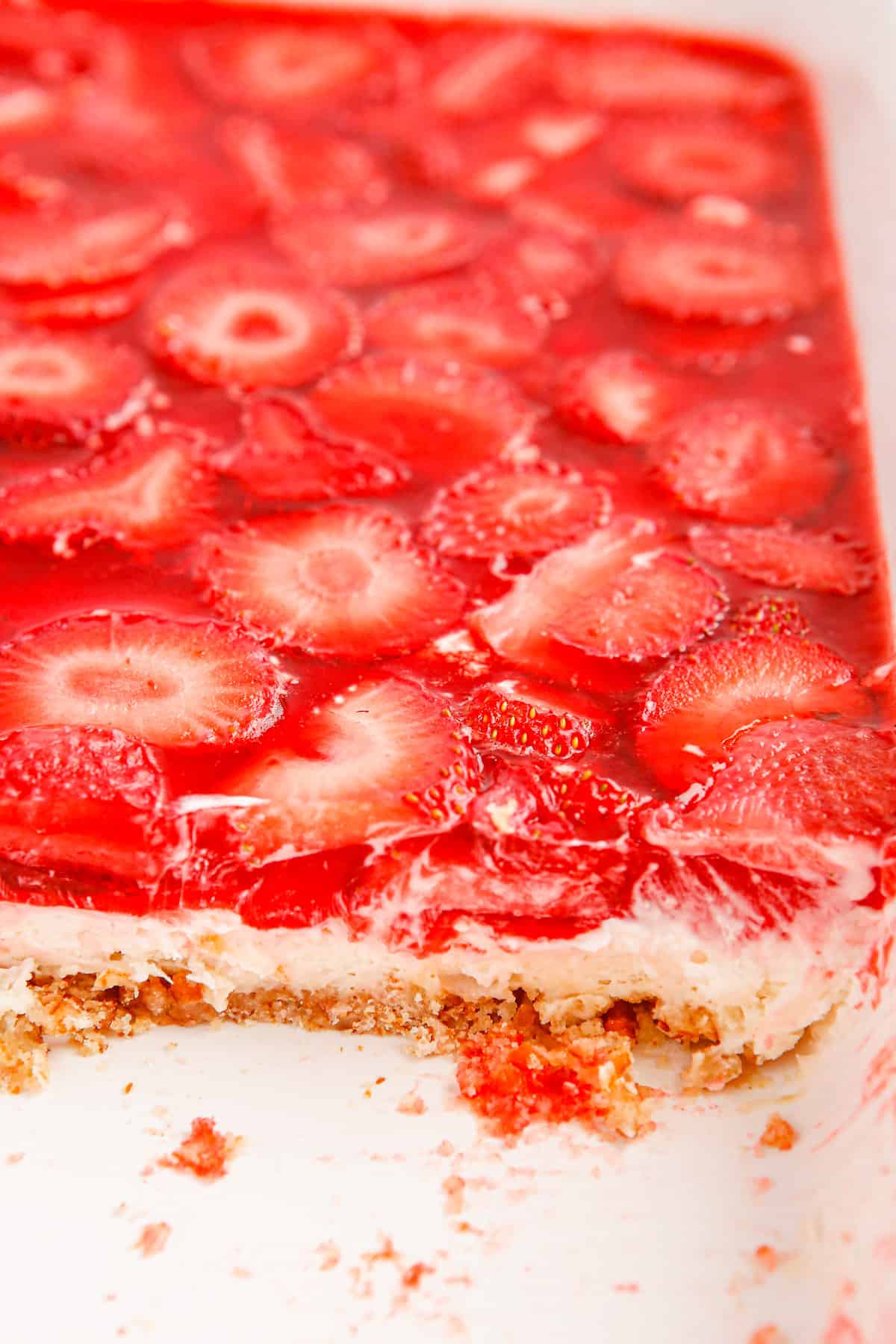 Old fashioned strawberry pretzel salad in baking dish with portion removed.