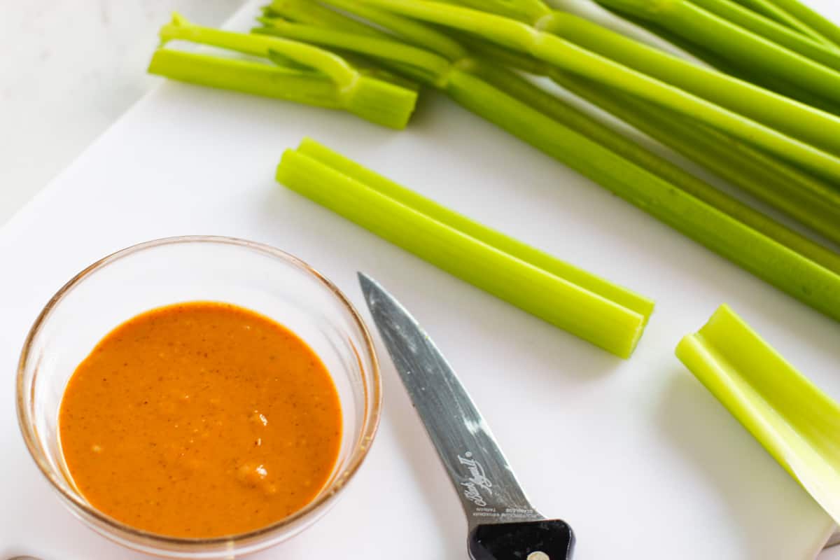 Sticks of celery and bowl of peanut butter.