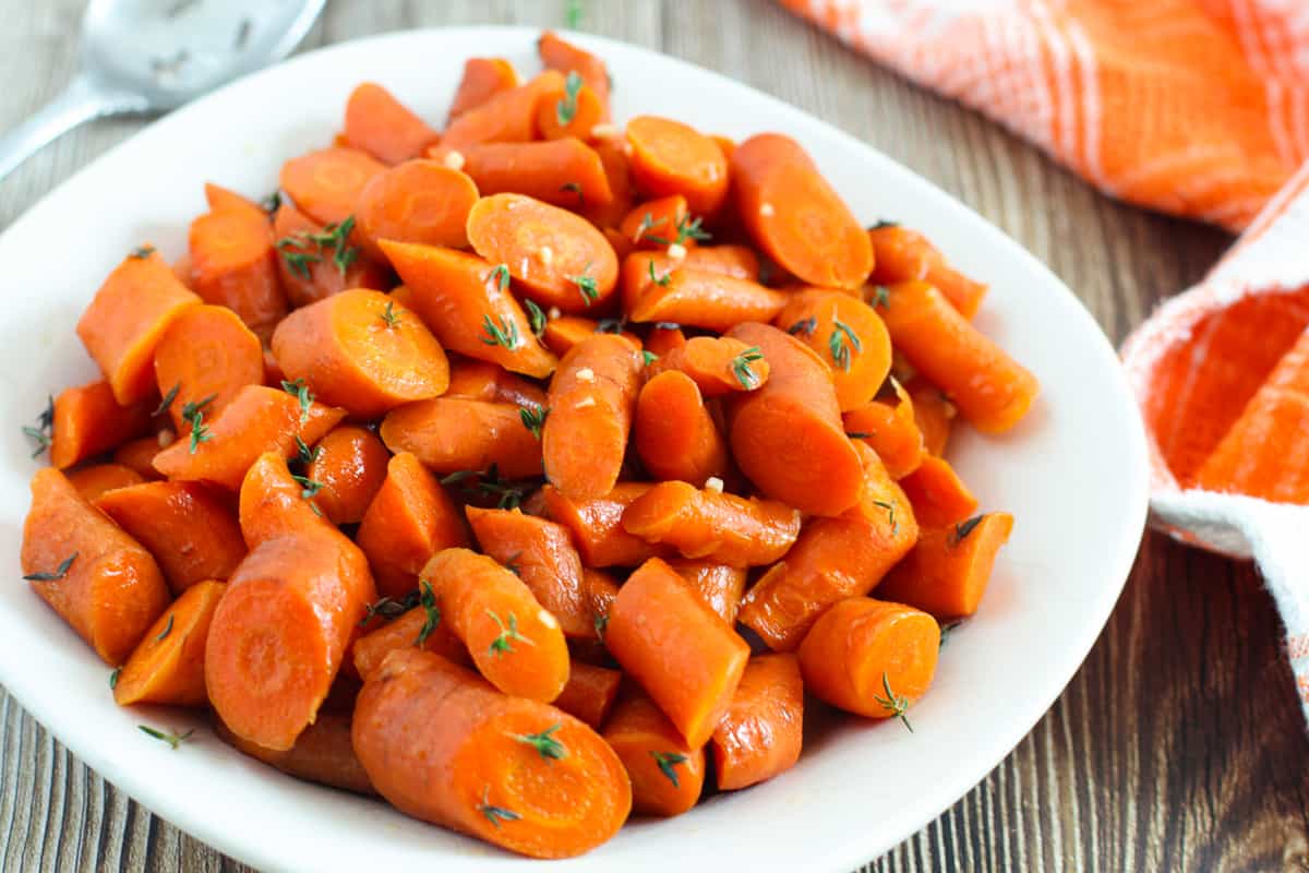 Slow cooker glazed carrots on white plate.