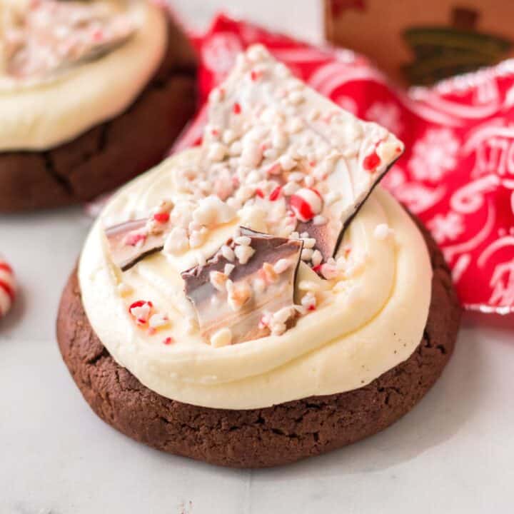 Thick chocolate cookie with buttercream frosting and shards of homemade peppermint bark.