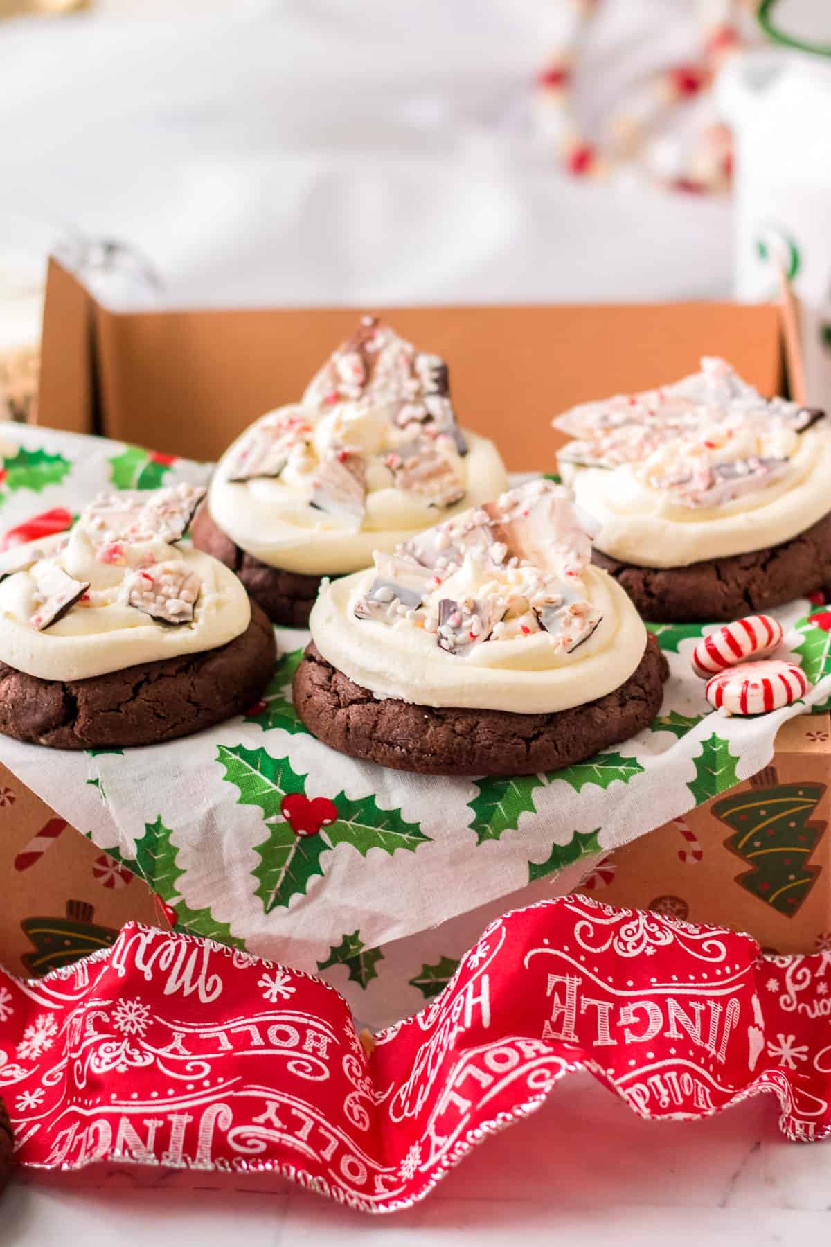 Chocolate peppermint bark cookies in gift box with mistletoe tissue paper.