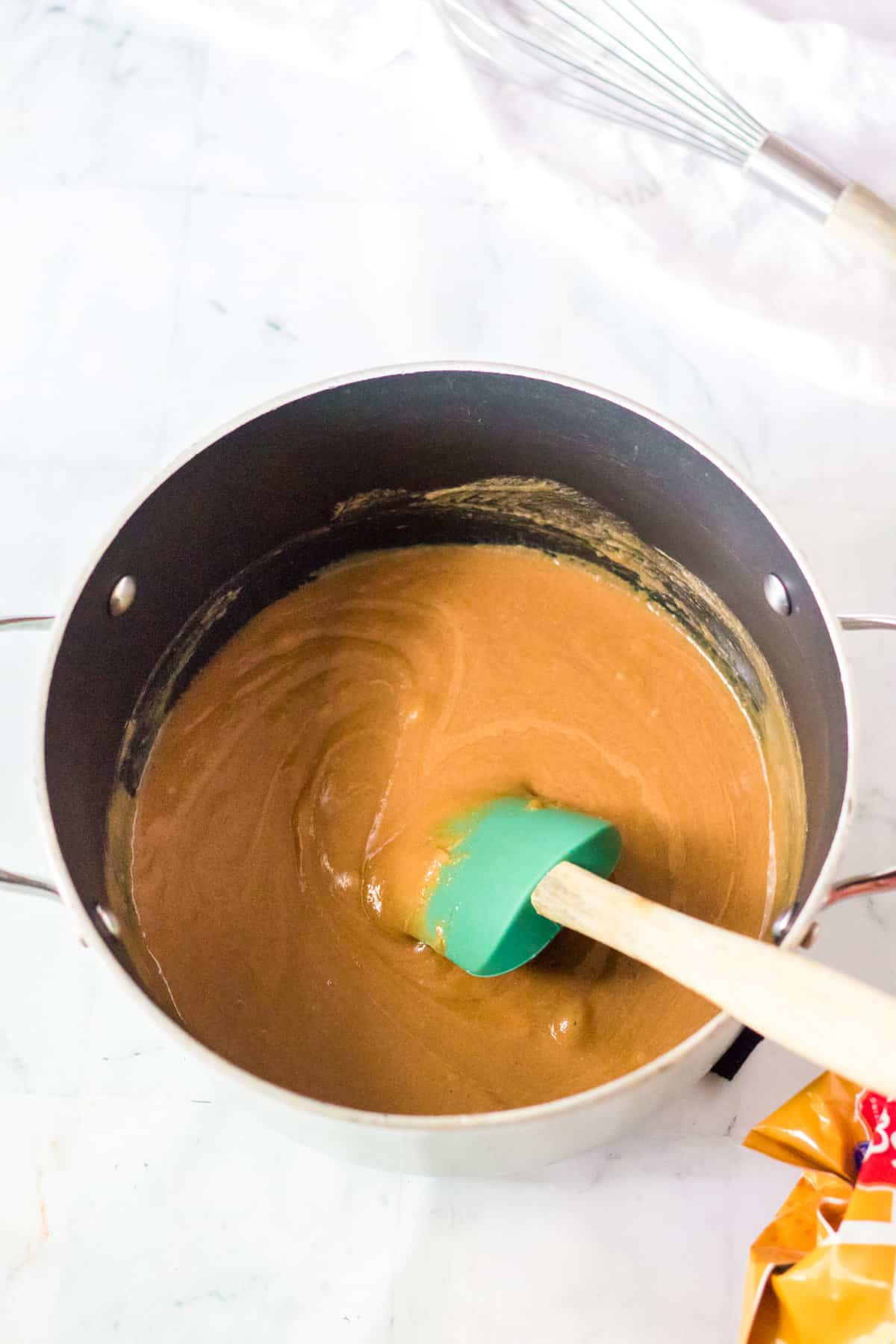 Saucepan with peanut butter mixture and rubber spatula.