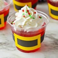 Santa jello cups with whipped cream and sprinkles.