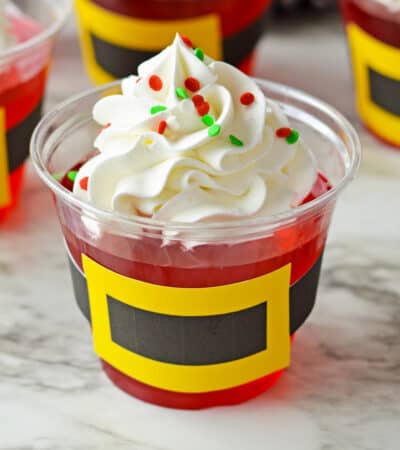 Santa jello cups with whipped cream and sprinkles.