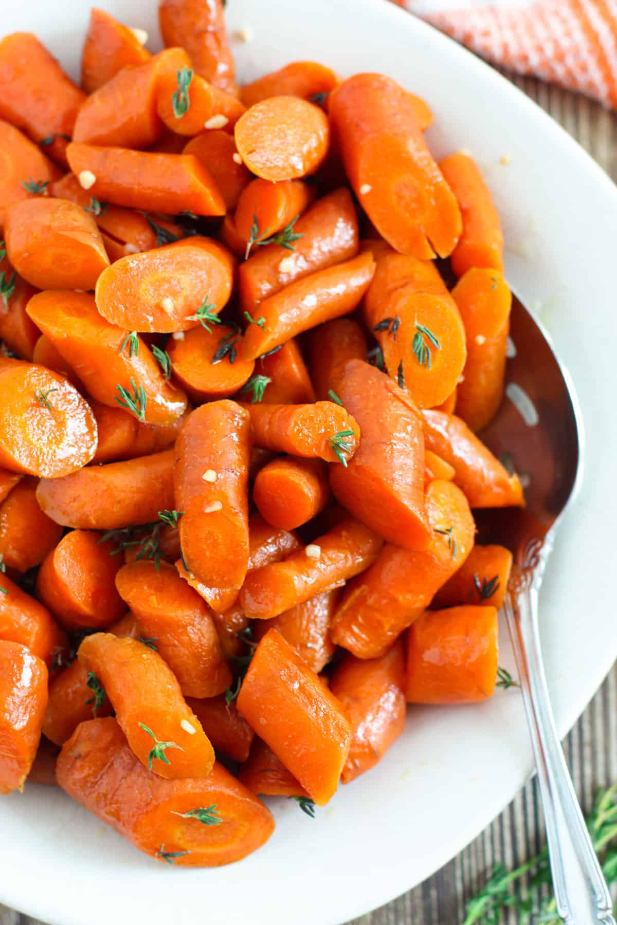 Slow cooker glazed carrots with serving spoon.