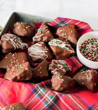 Honeycomb candy coated in chocolate and topped with white chocolate drizzle and Christmas sprinkles.