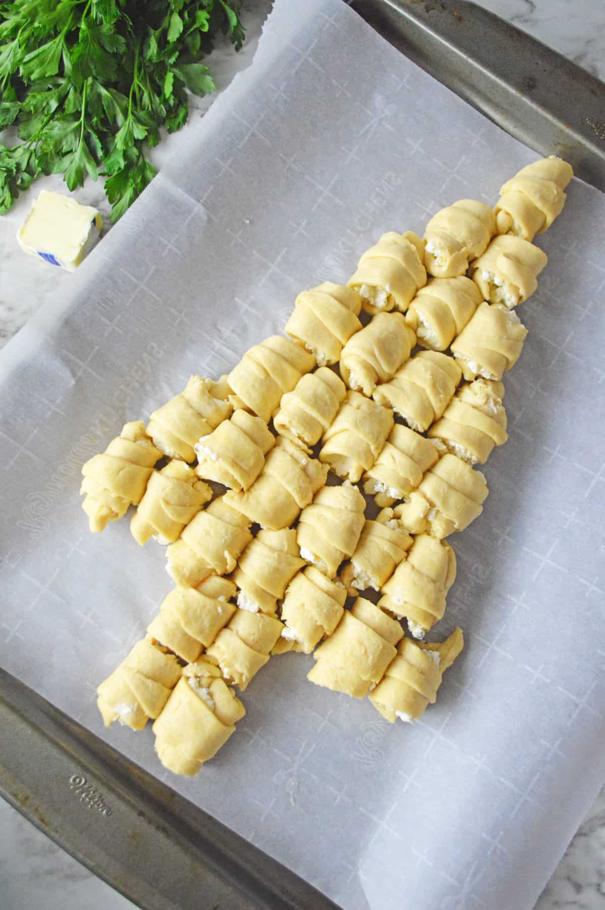 Rolled crescents on lined baking sheet in shape of a Christmas Tree.