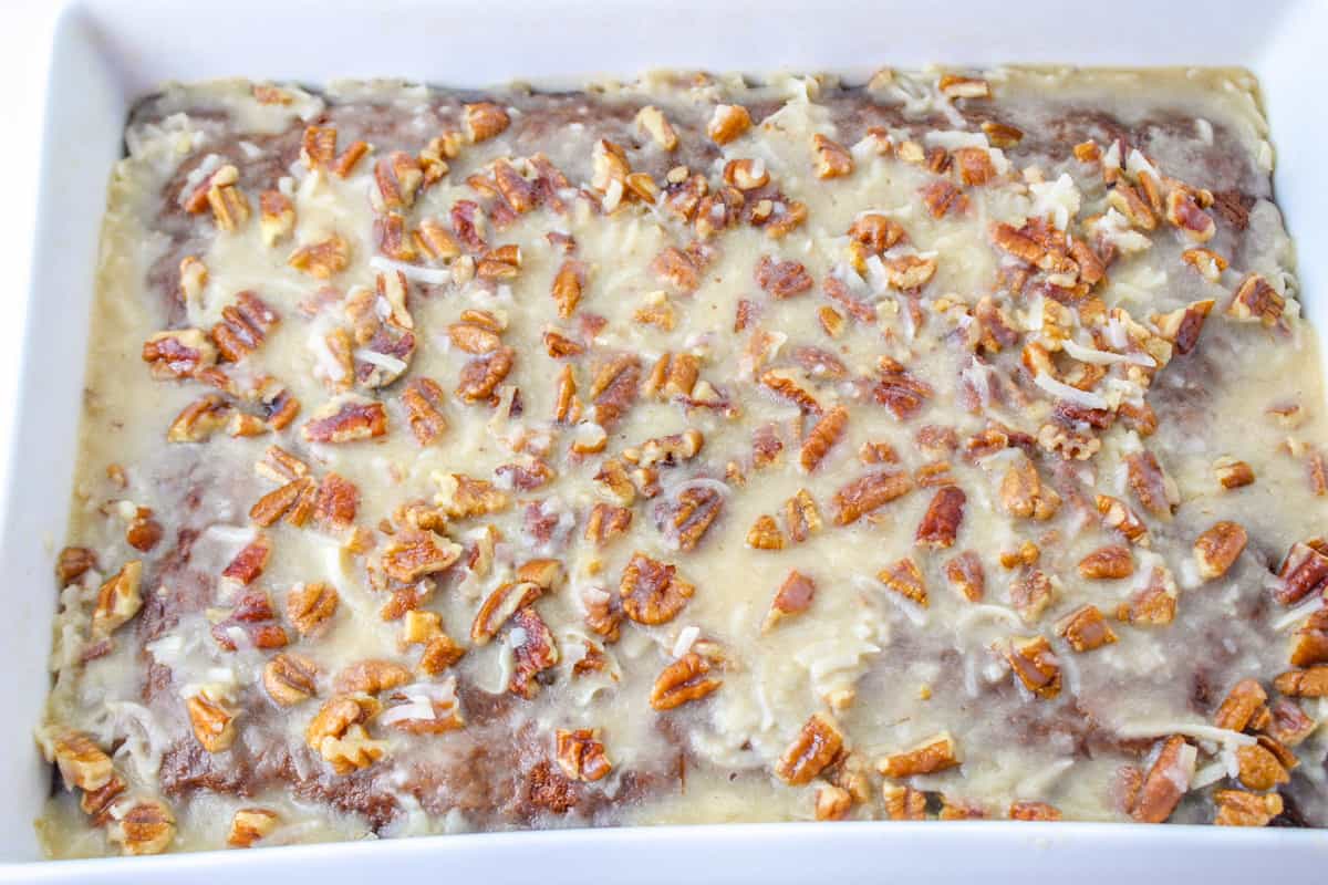 Fruit cocktail cake with coconut pecan frosting in rectangular baking dish.