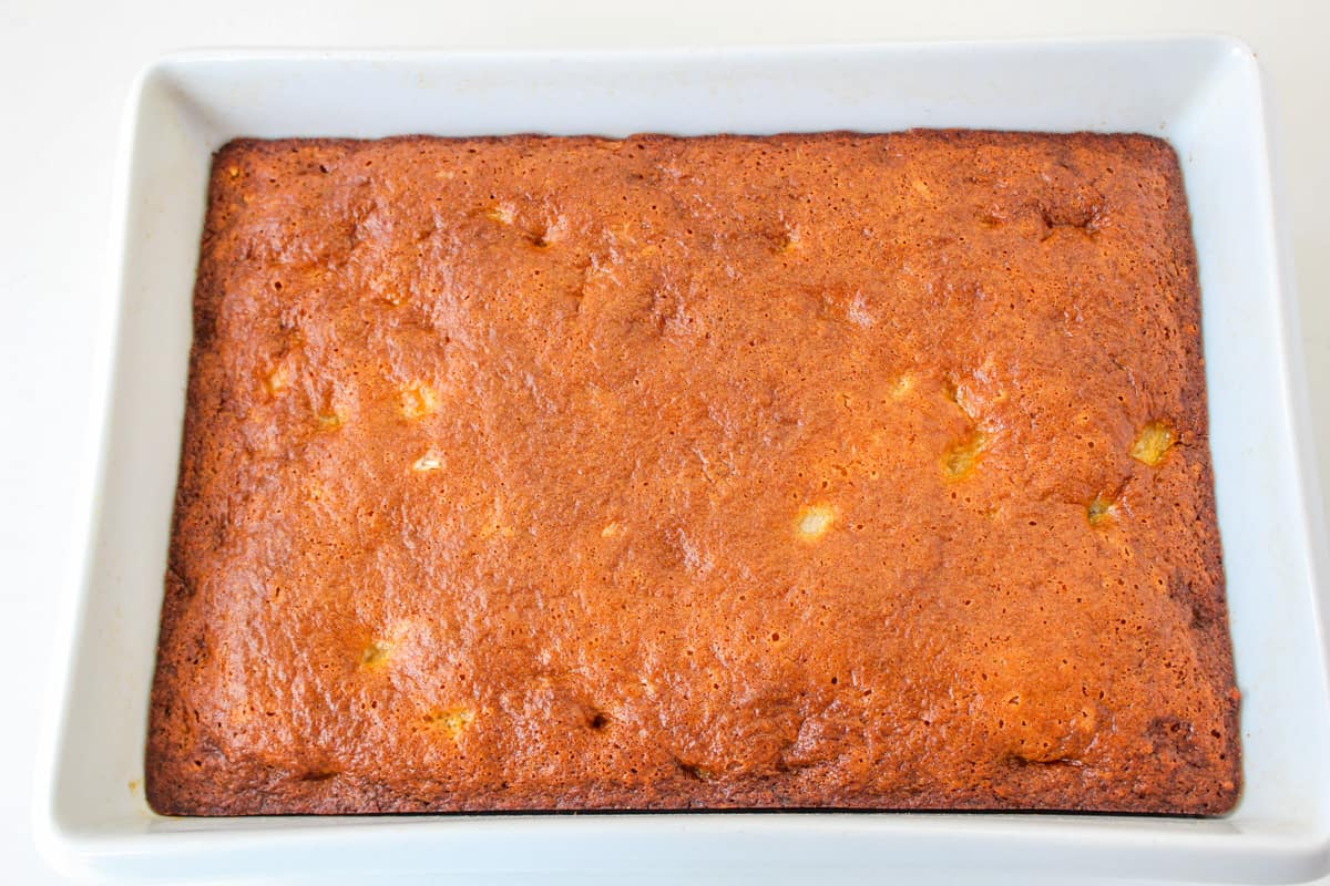 Fruit cocktail cake in baking pan with golden brown top.
