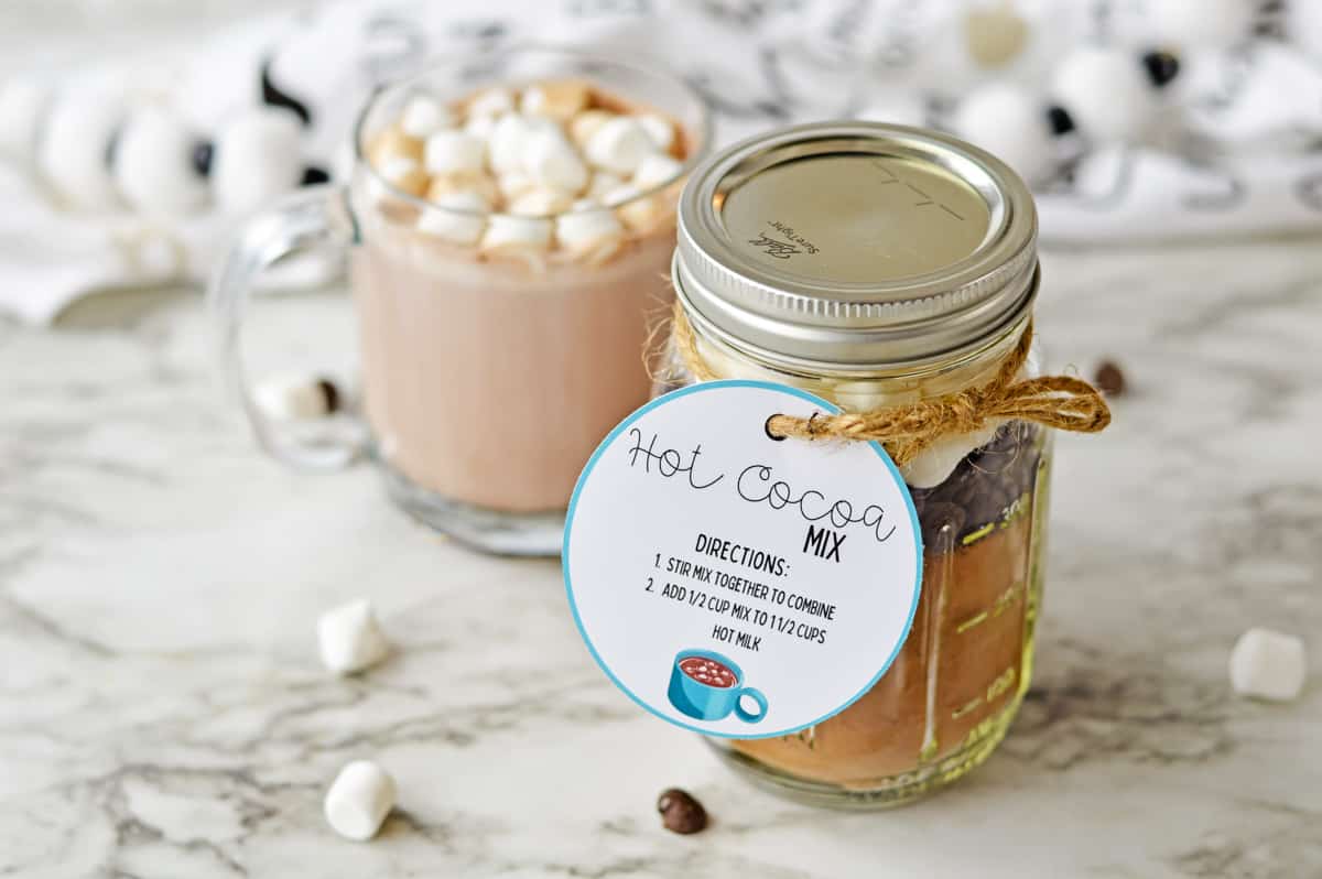 Homemade hot chocolate mix in a jar and cup of hot cocoa with marshmallows.
