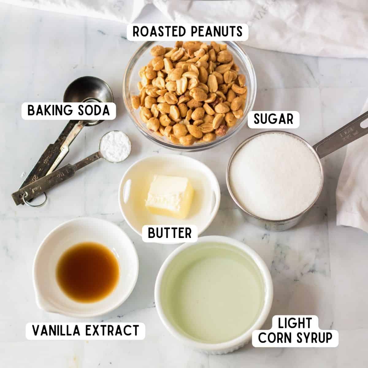 Ingredients for peanut brittle: peanuts, vanilla extract, granulated sugar, butter, light corn syrup, and baking soda.