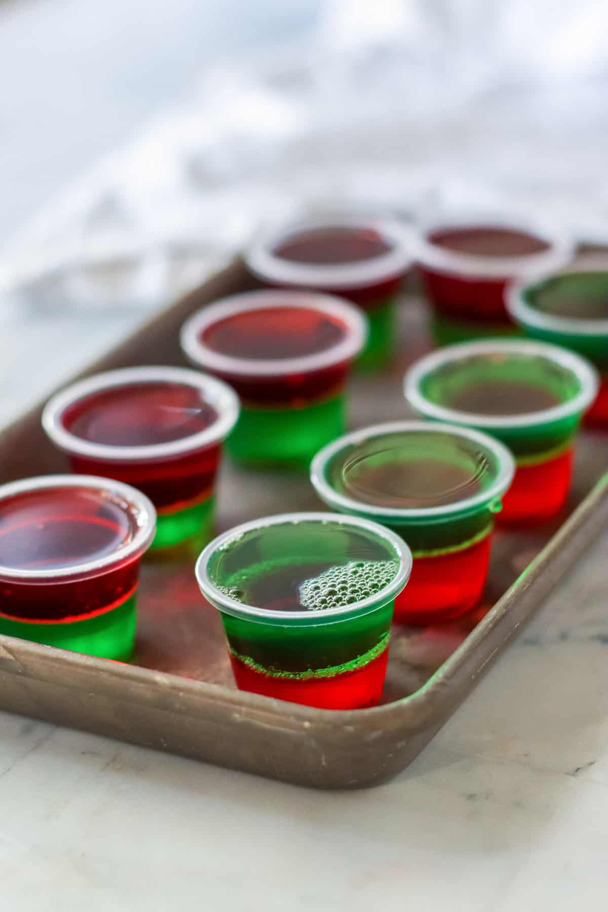 Layered red and green shots on metal tray.