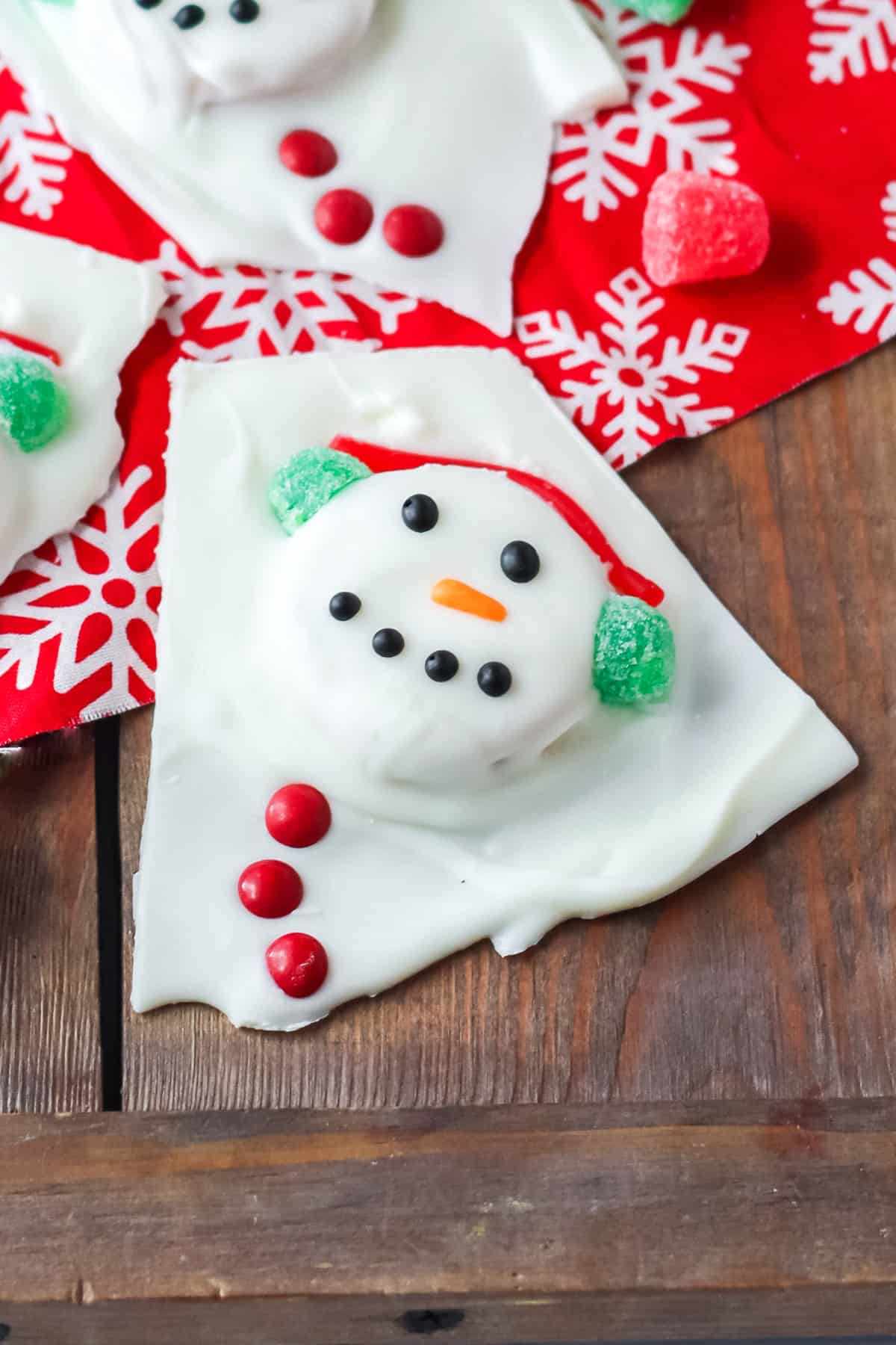 Piece of adorable snowman bark with candy earmuffs and buttons.