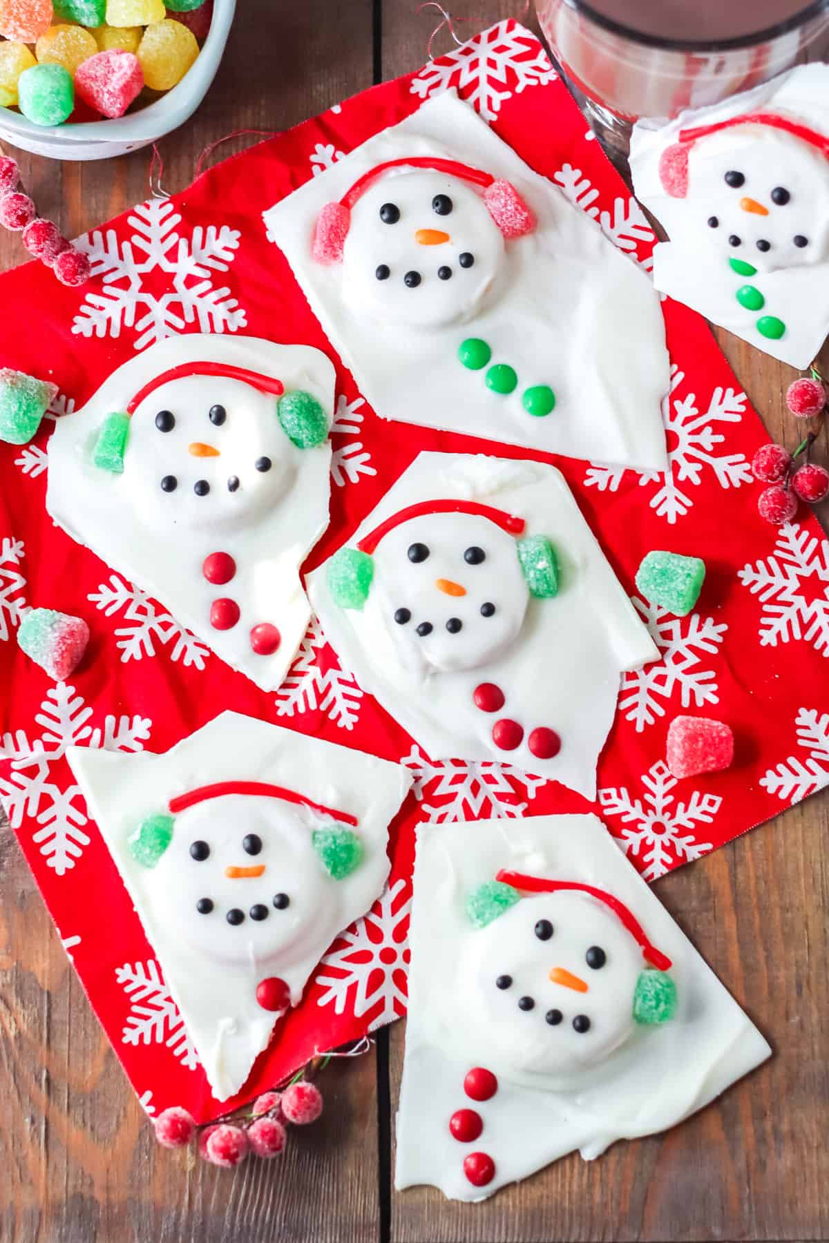 Melted snowman bark with gumdrop earmuffs, mini m&m buttons, and faces drawn on with icing.