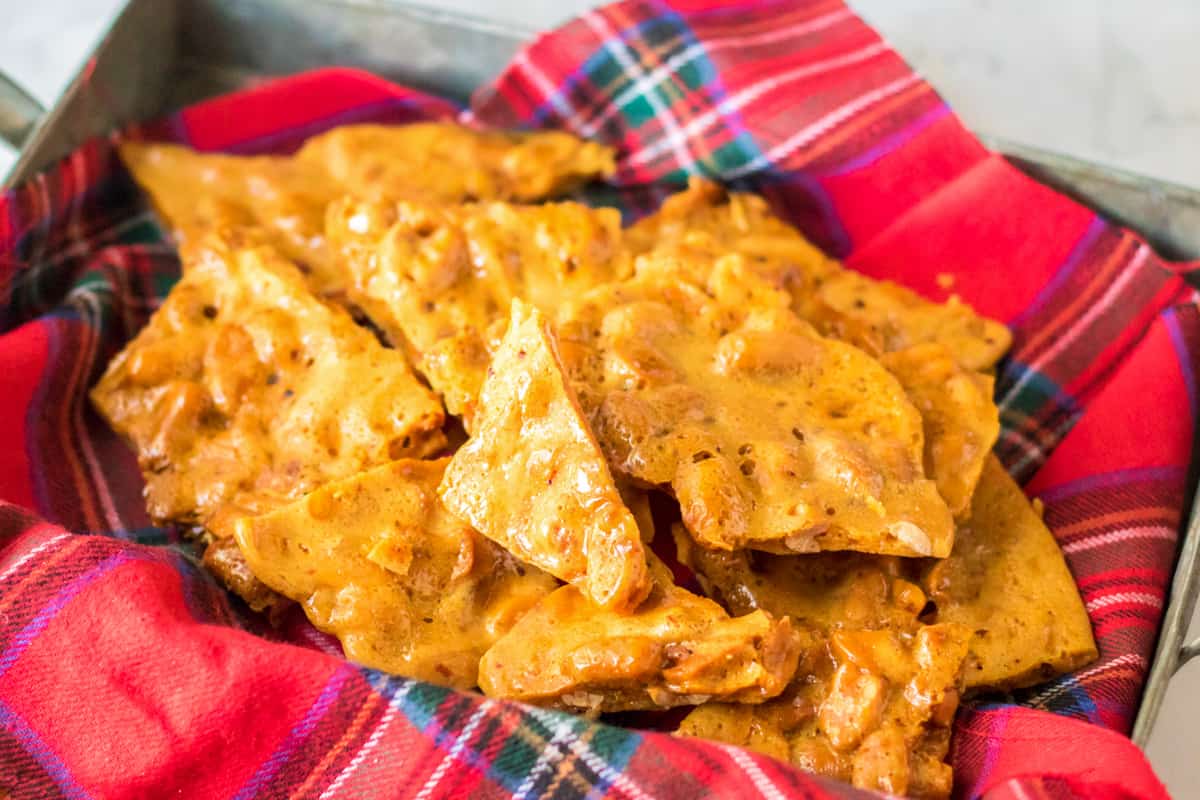 Microwave peanut brittle pieces in Christmas candy tin.