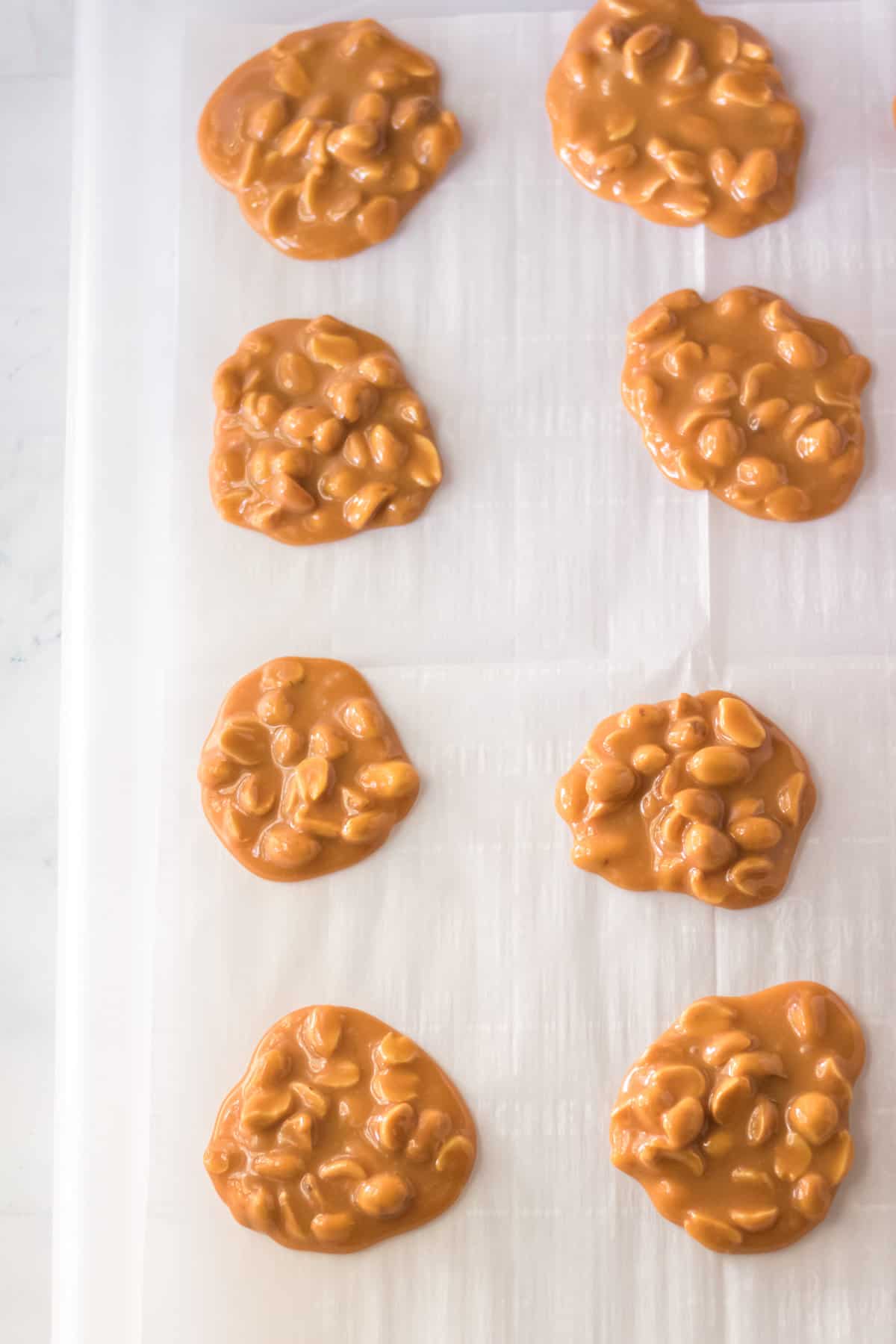 Peanut and caramel clusters on parchment paper.