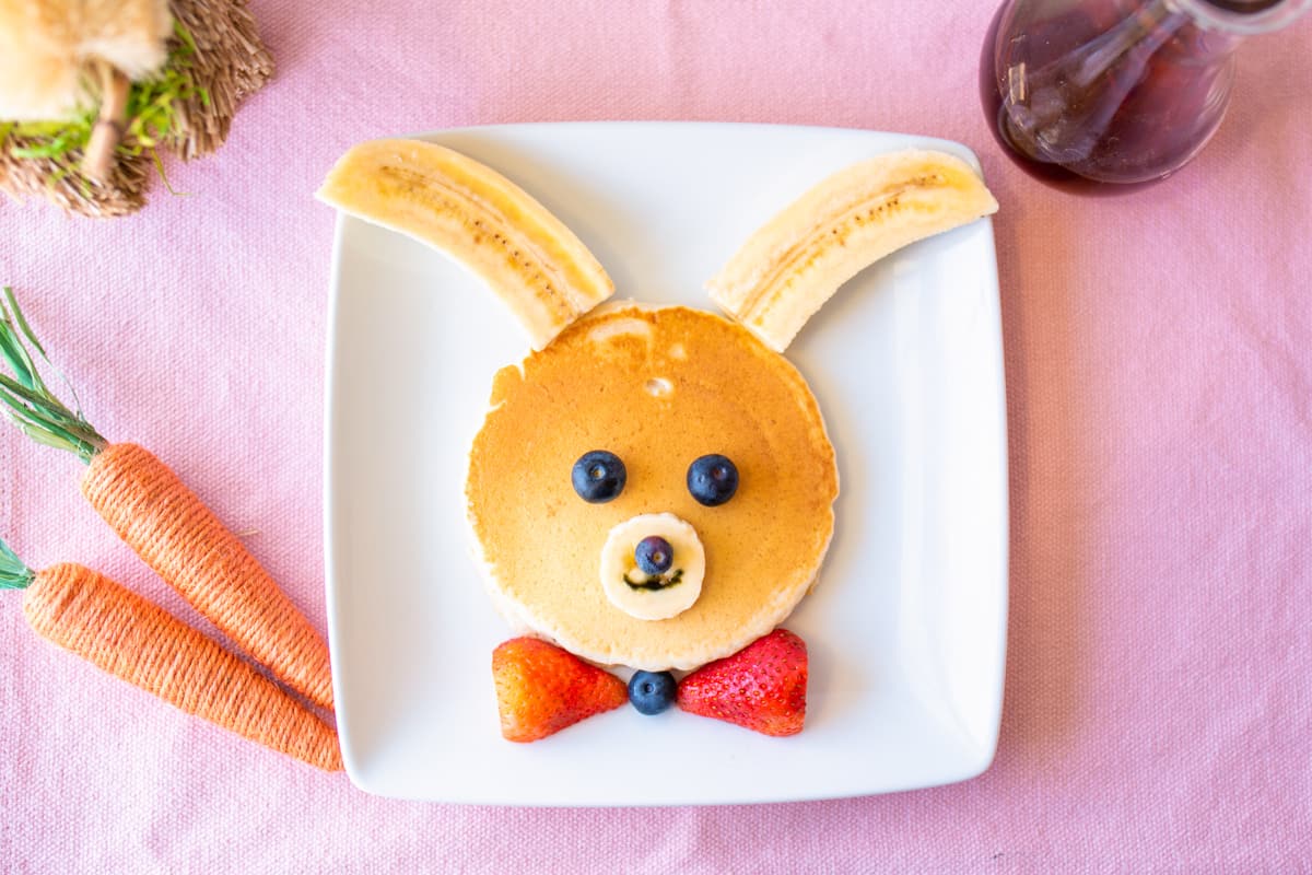 Bunny pancakes decorated with bananas and berries.