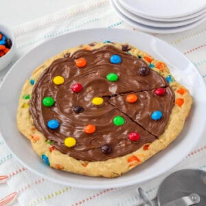 M&M skillet cookie pizza with an M&M cookie base, chocolate topping, and colorful M&M candies on top.