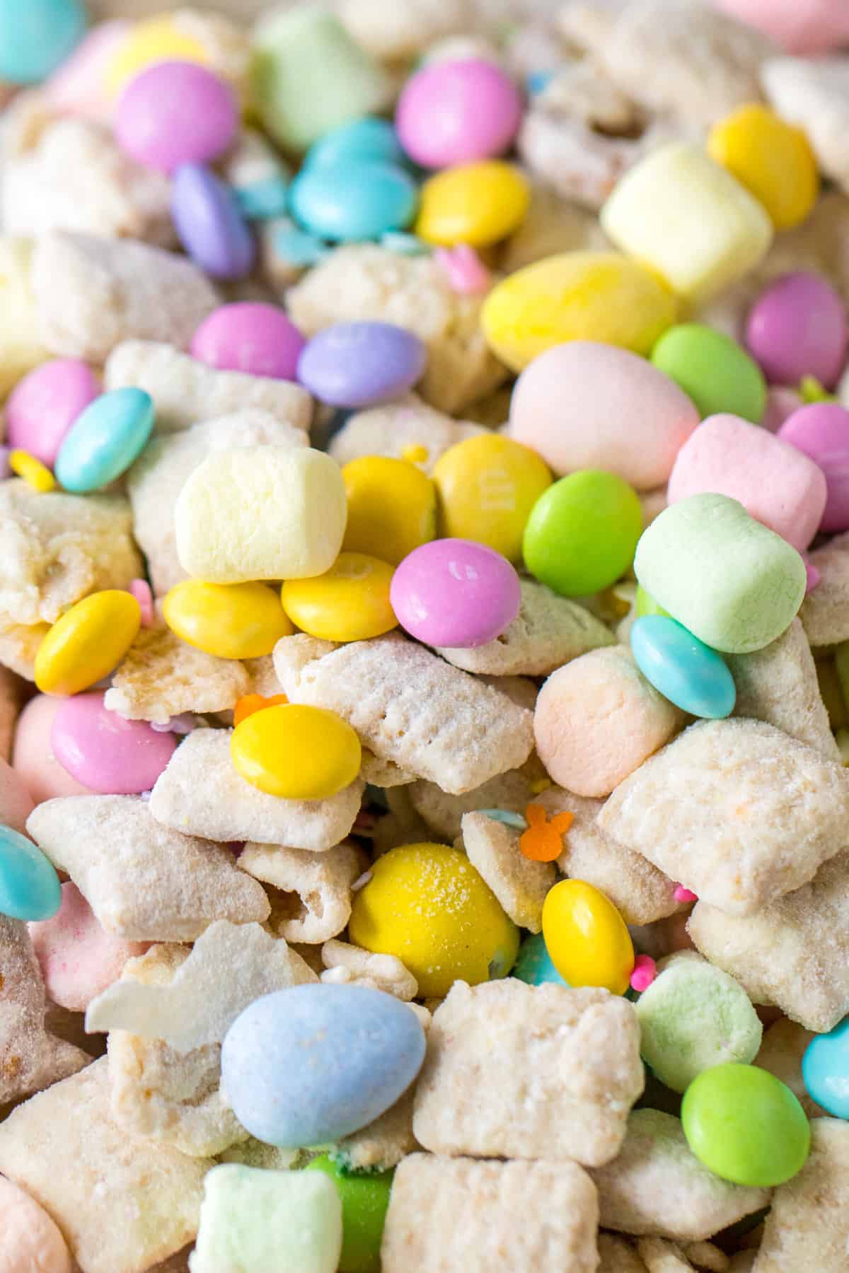 Close up of muddy buddy snack mix with pastel marshmallows and candies.