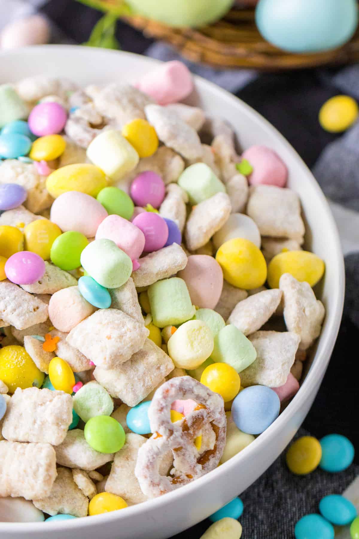 Easter muddy buddy chex mix with pretzels, pastel mini marshmallows, M&Ms, mini eggs, and sprinkles.