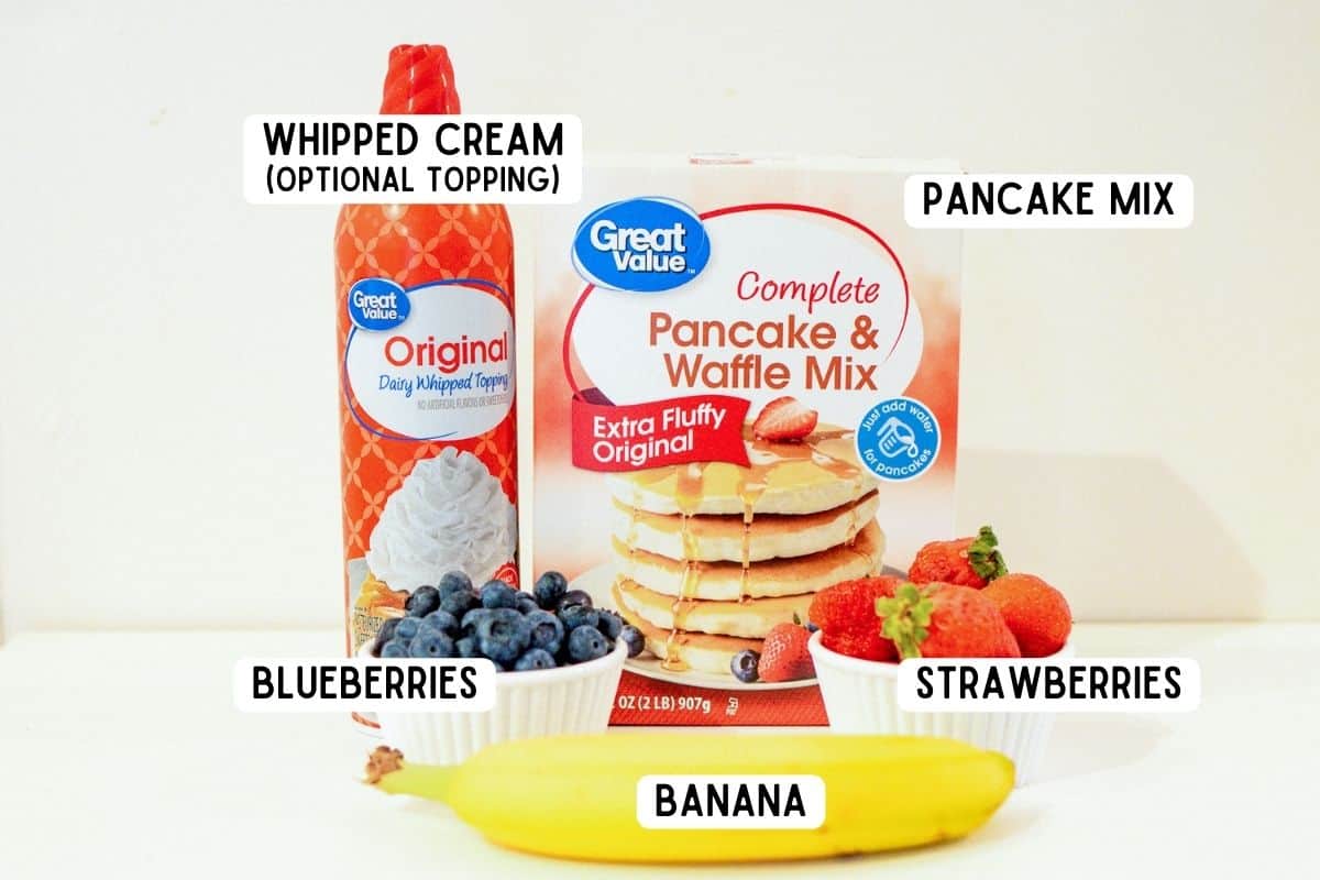 Ingredients for bunny pancakes: complete pancake mix, strawberries, blueberries, banana, and optional whipped cream.