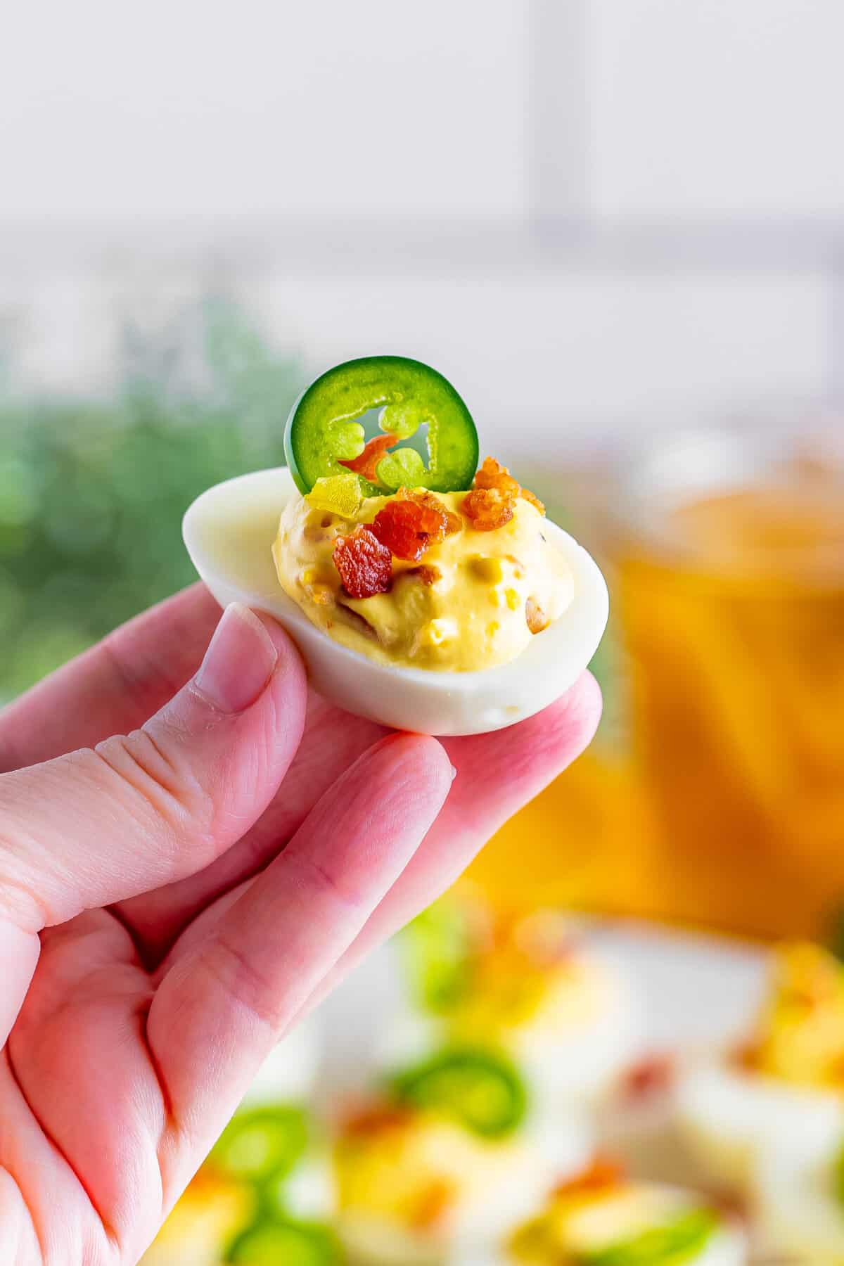 Hand holding a jalapeno deviled eggs.