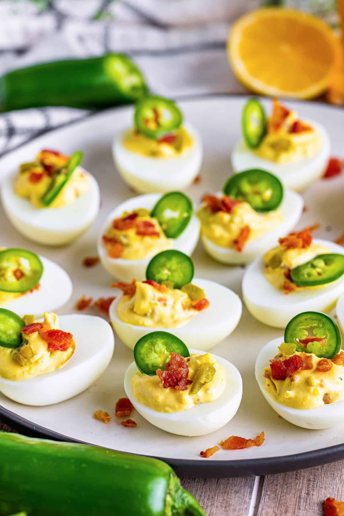 Jalapeno popper deviled eggs topped with crumbled bacon and a slice of jalapeno.