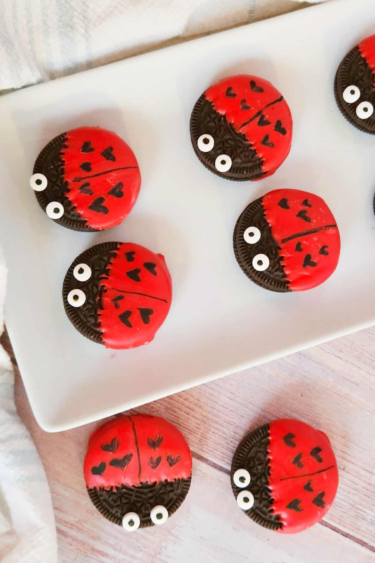 Oreo cookies decorated like love bugs arranged on a white platter.