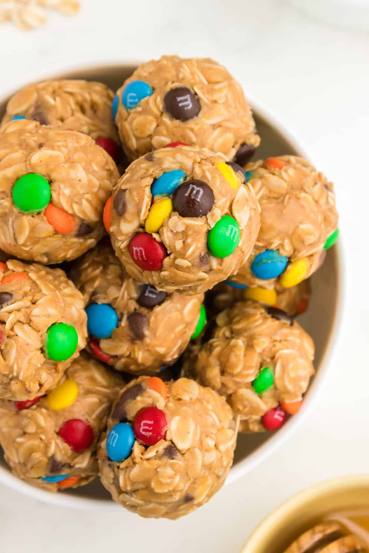 Bowl of no-bake energy balls with oats, chocolate chips, and M&Ms.