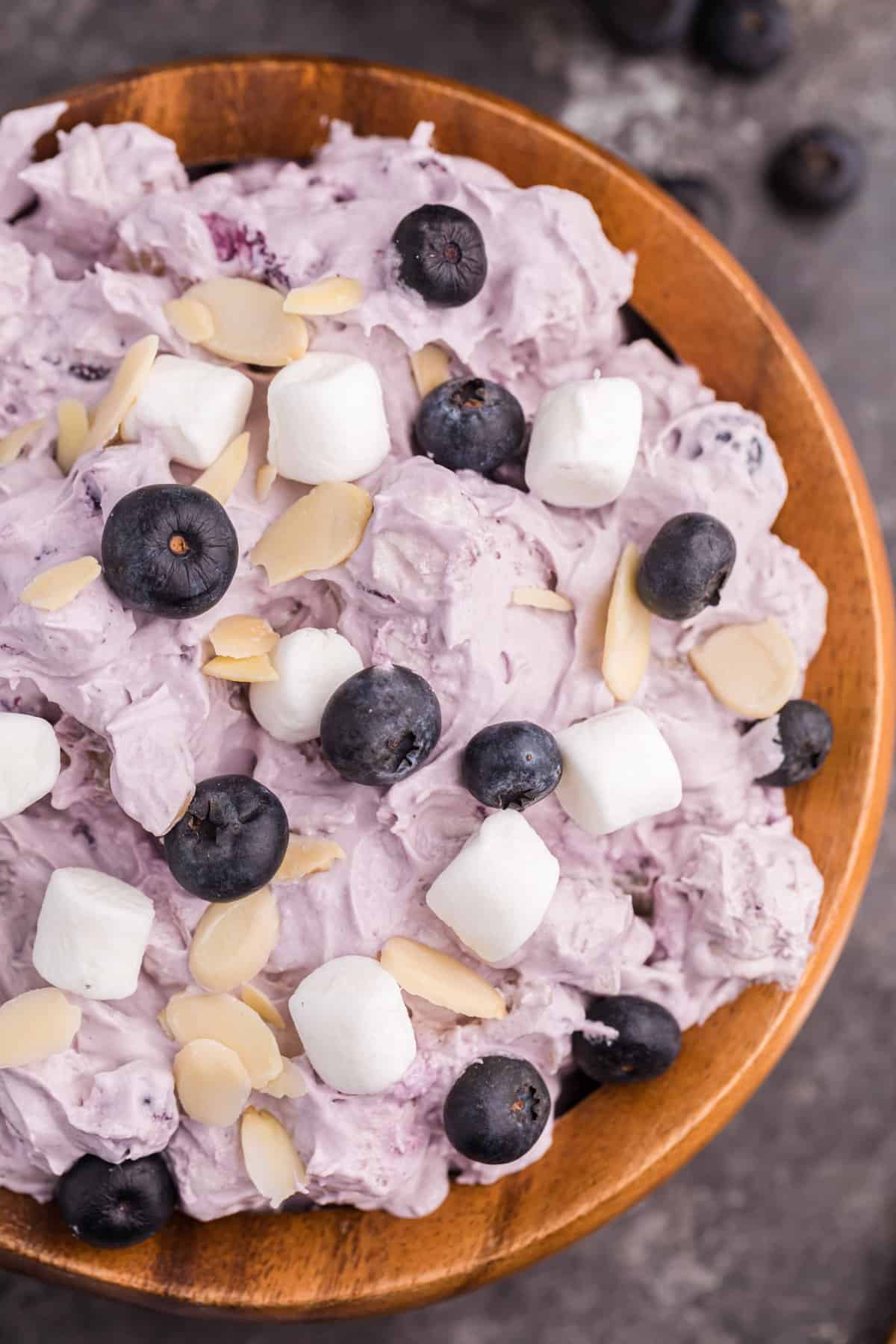 Light and creamy blueberry fluff dessert salad topped with blueberries, marshmallows, and sliced almonds,