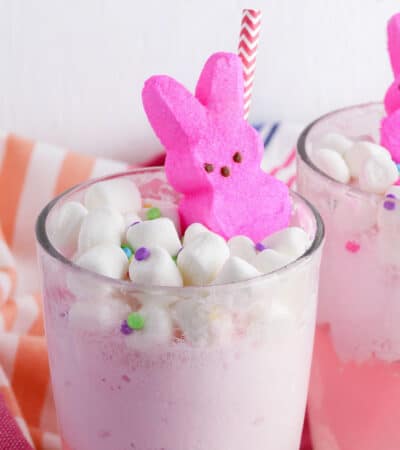 Easter Punch topped with mini marshmallows, confetti-style sprinkles, pink marshmallow Peeps, and a pink and white paper straw.