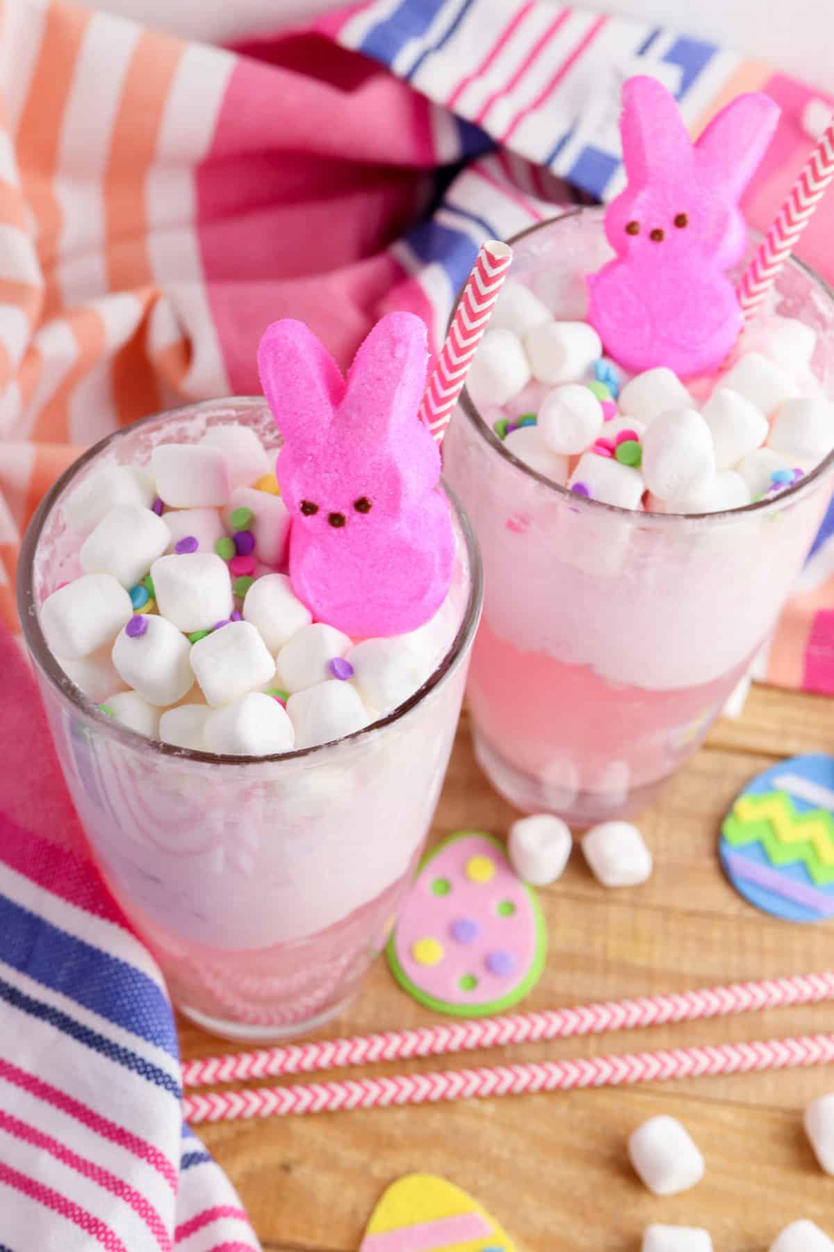 Two glasses with a pink Easter drink topped with marshmallows and peeps.