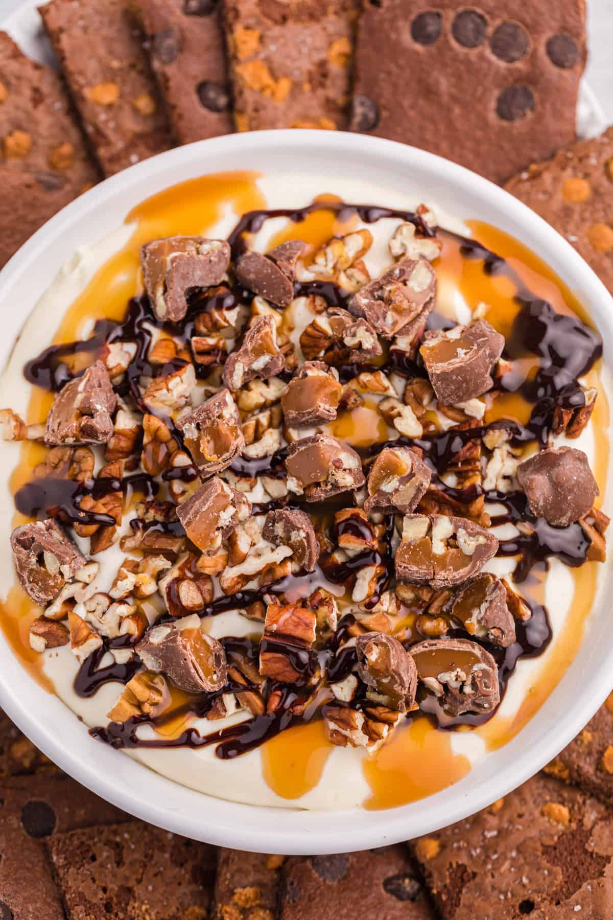 Overhead view of Turtle dip in serving bowl surrounded by brownie brittle dippers.