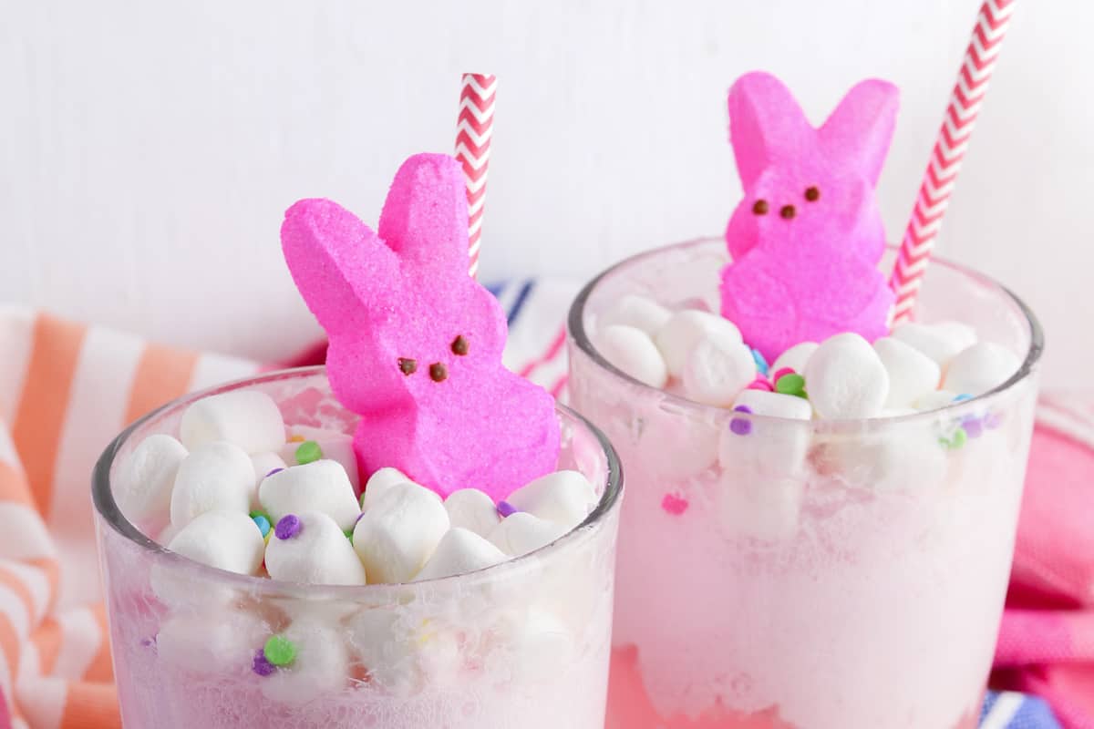 Easter Punch topped with mini marshmallows, confetti-style sprinkles, pink marshmallow Peeps, and a pink and white paper straw.
