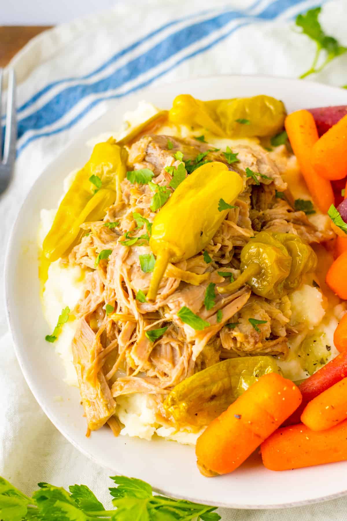Juicy slow cooker Mississippi pork roast with pepperoncinis and carrots.
