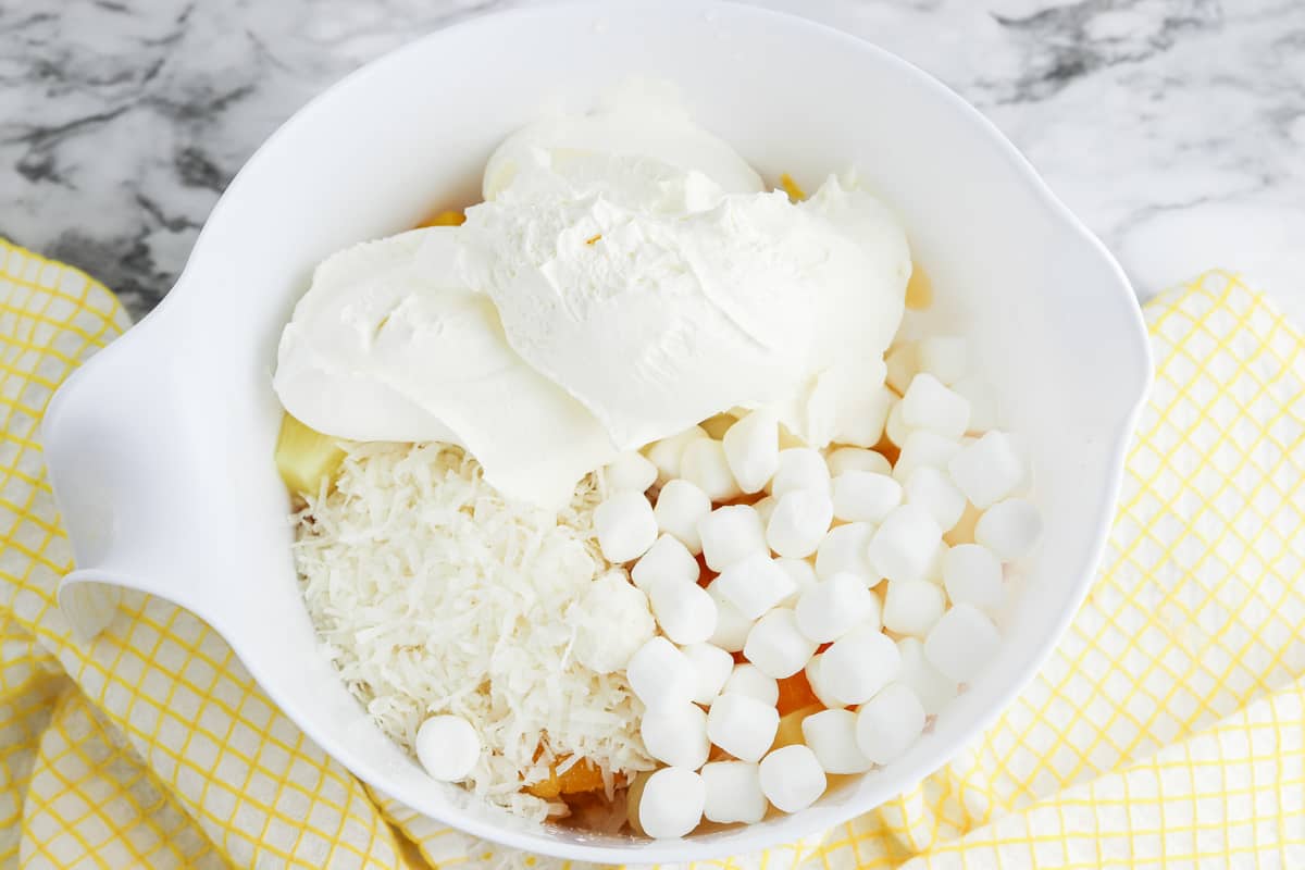 Mini marshmallows, whipped topping, and shredded coconut added to mixing bowl.