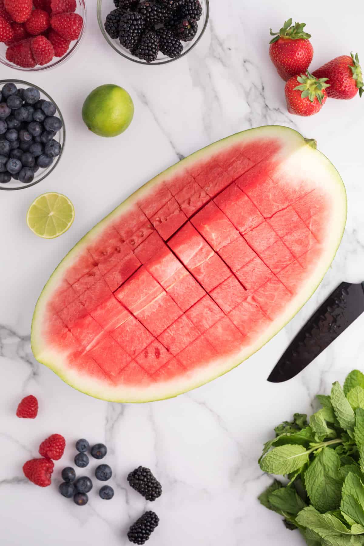 Watermelon being sliced into cubes.