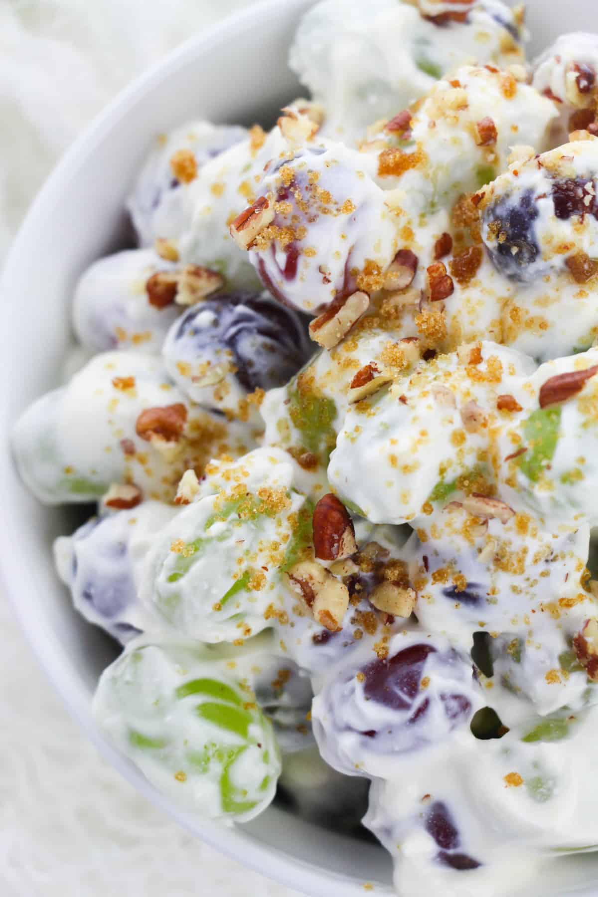 Grape salad with crunchy pecan and brown sugar topping sprinkled over it.