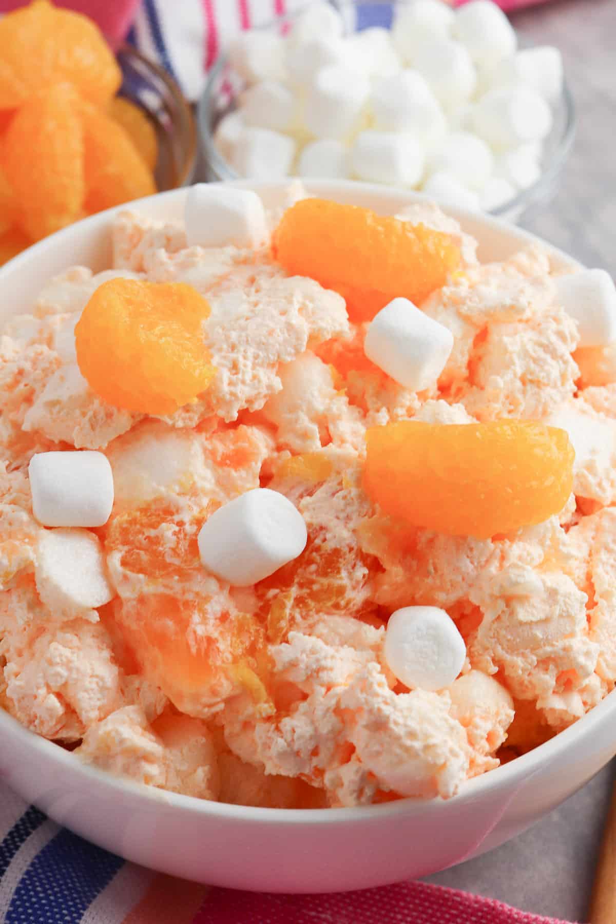 Bowl of mandarin orange jello salad with marshmallows.