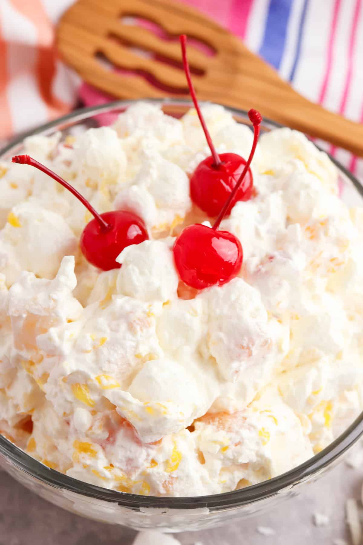 Marshmallow Fruit Salad garnished with 3 Maraschino cherries on top.