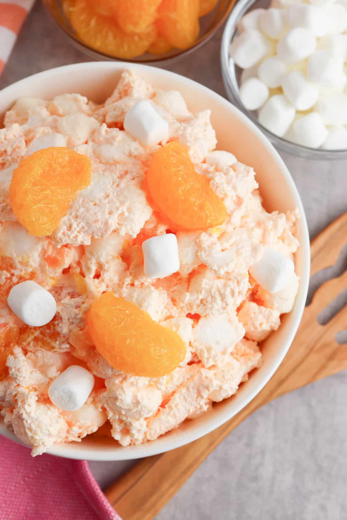 Fluffy orange jello salad with mandarin oranges and mini marshmallows.