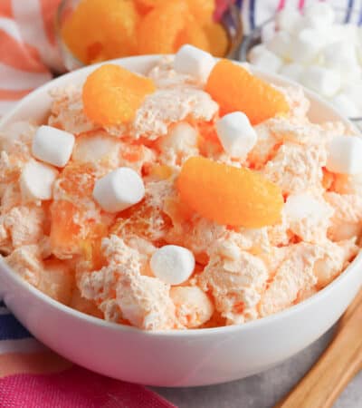 Orange fluff salad with mini marshmallows, mandarin oranges, and jello.