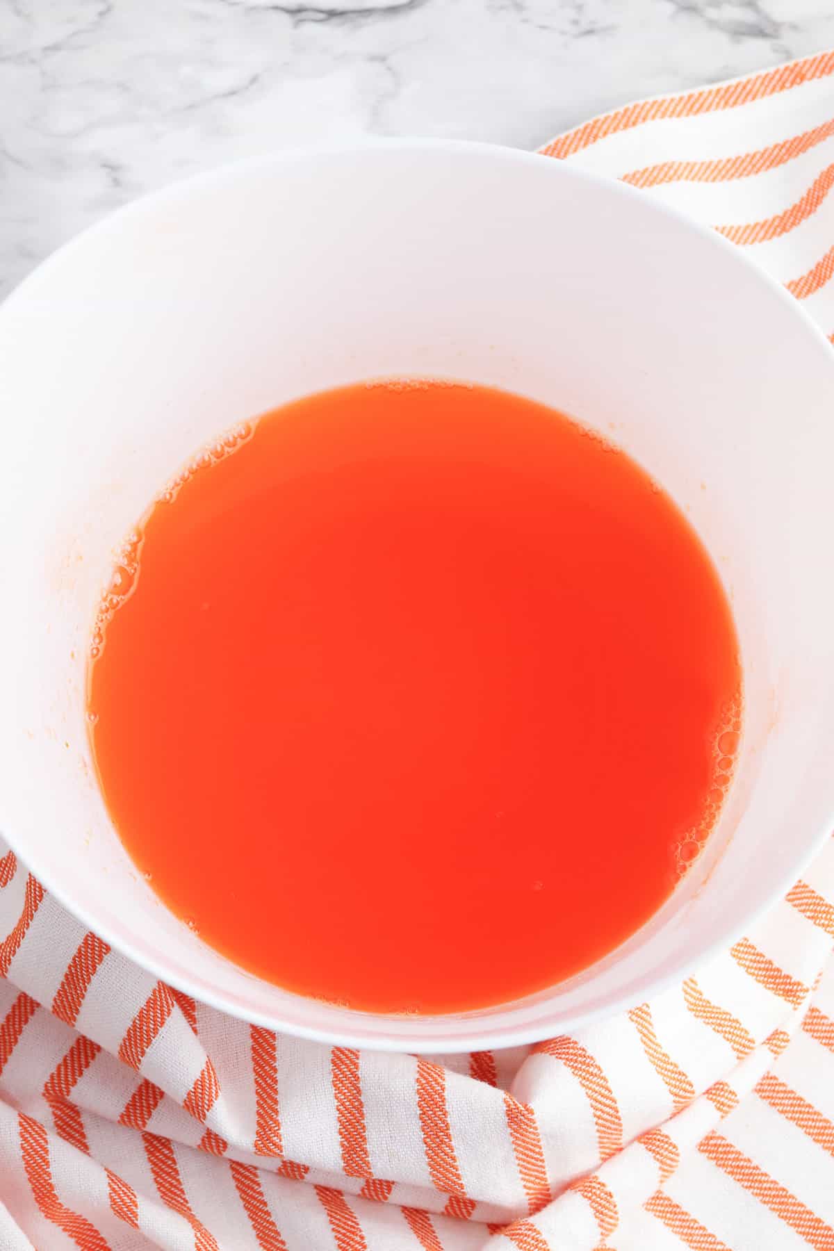 Orange jello in a mixing bowl.