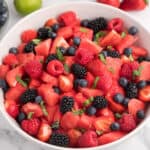 Watermelon fruit salad with fresh berries and thinly sliced mint leaves.