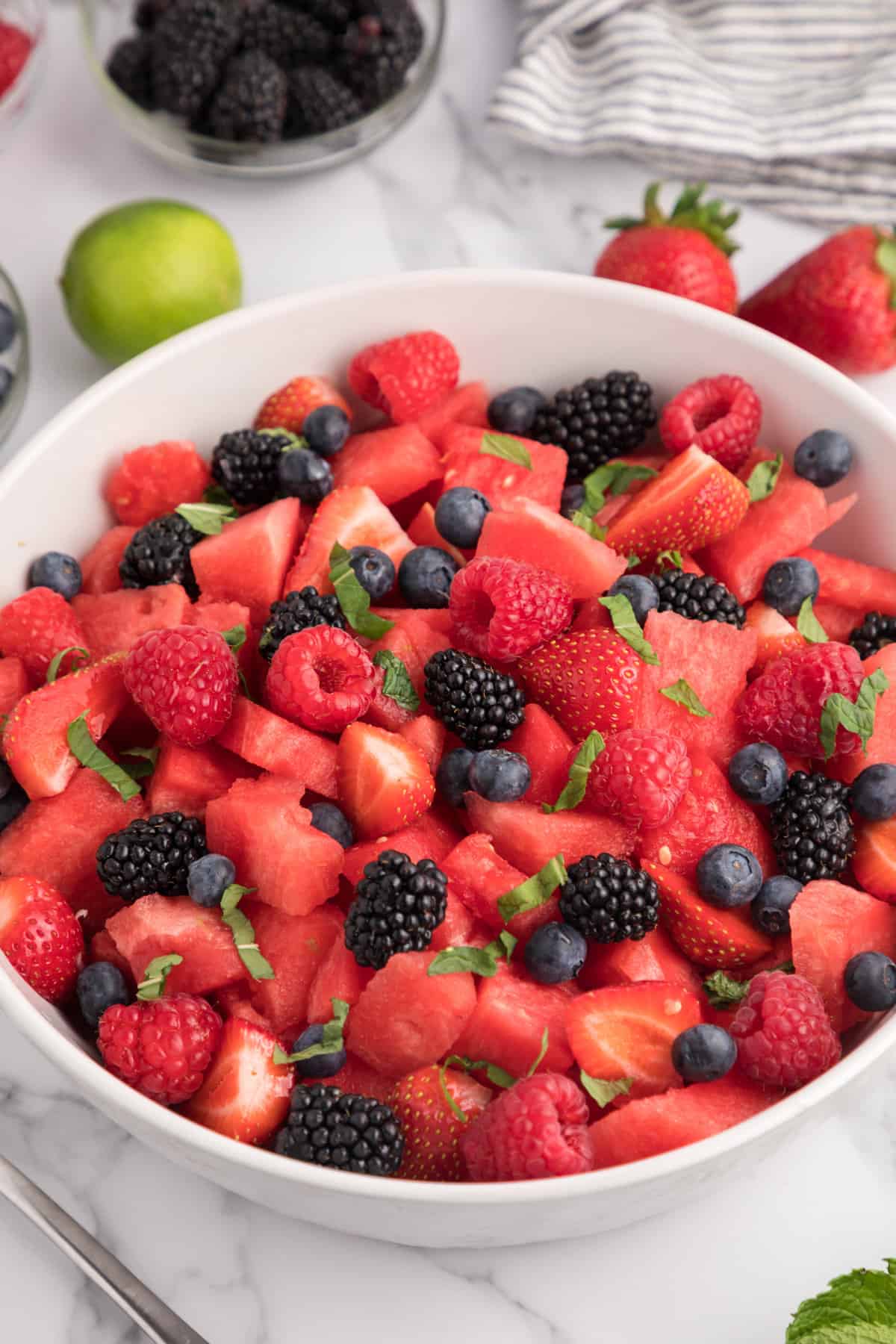 Watermelon Fruit Salad with fresh berries and a lime mint dressing in a large serving bowl.