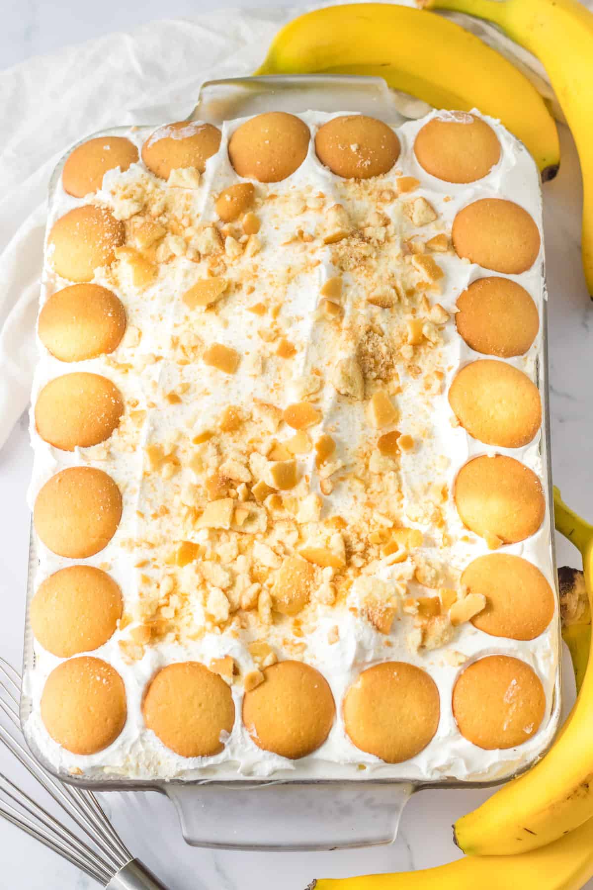 Whipped cream and nilla wafer topped poke cake The cookies are placed on top to create a border around the perimeter and vanilla wafer crumbs are scattered in the center.