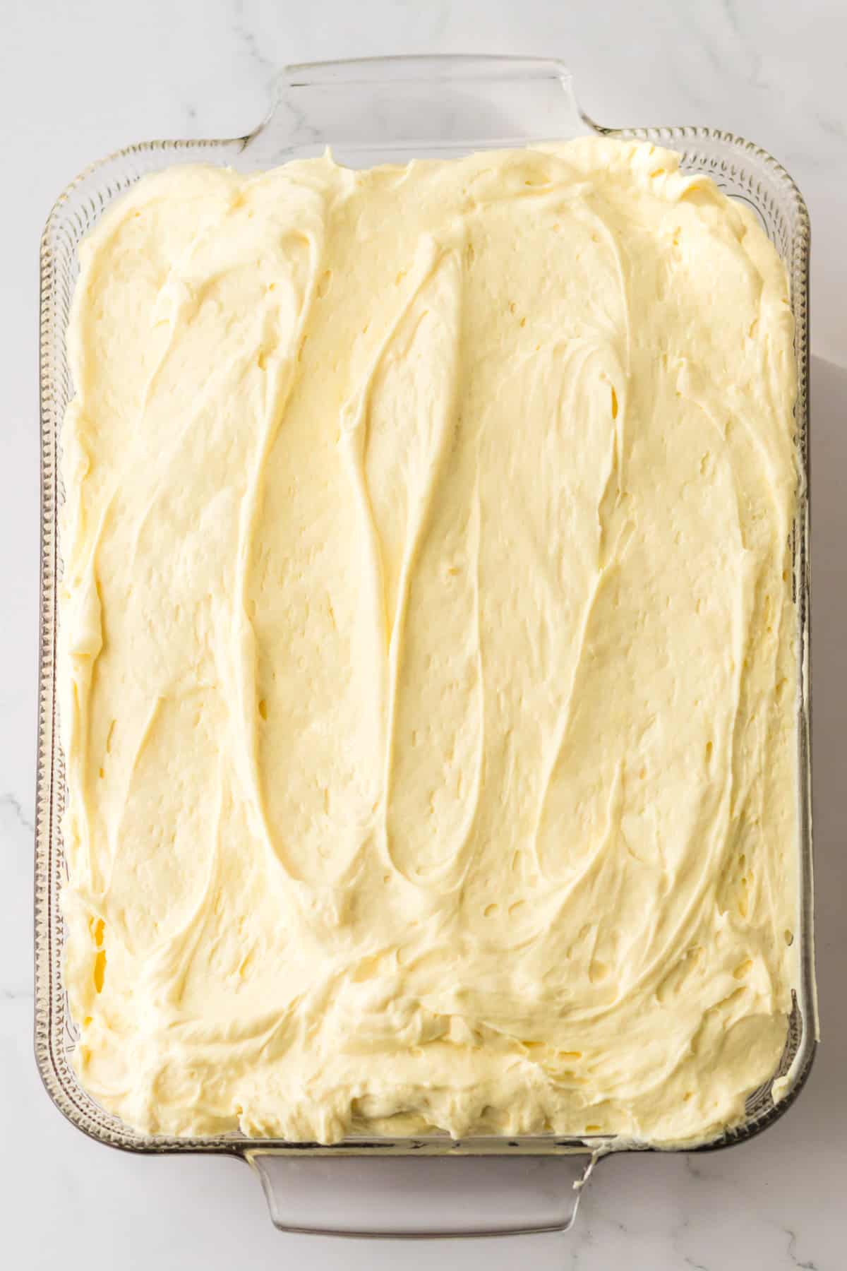 Cake topped with cream cheese pudding mixture spread into an even layer.