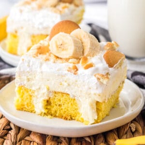 Banana pudding poke cake with slices of fresh banana and vanilla wafers on top.