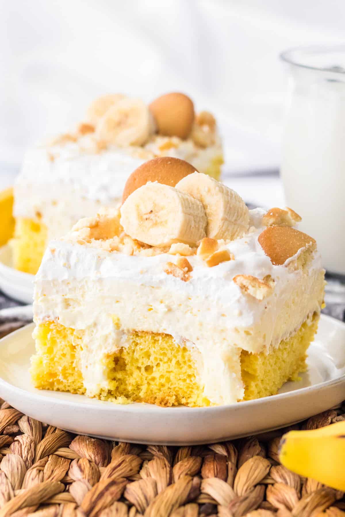 Banana pudding poke cake topped with fresh banana and nilla wafers.